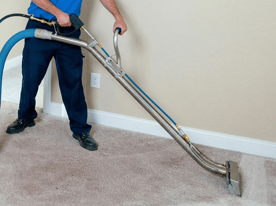 Professional operating a liquid removal machine on a carpeted floor in Nashville, TN